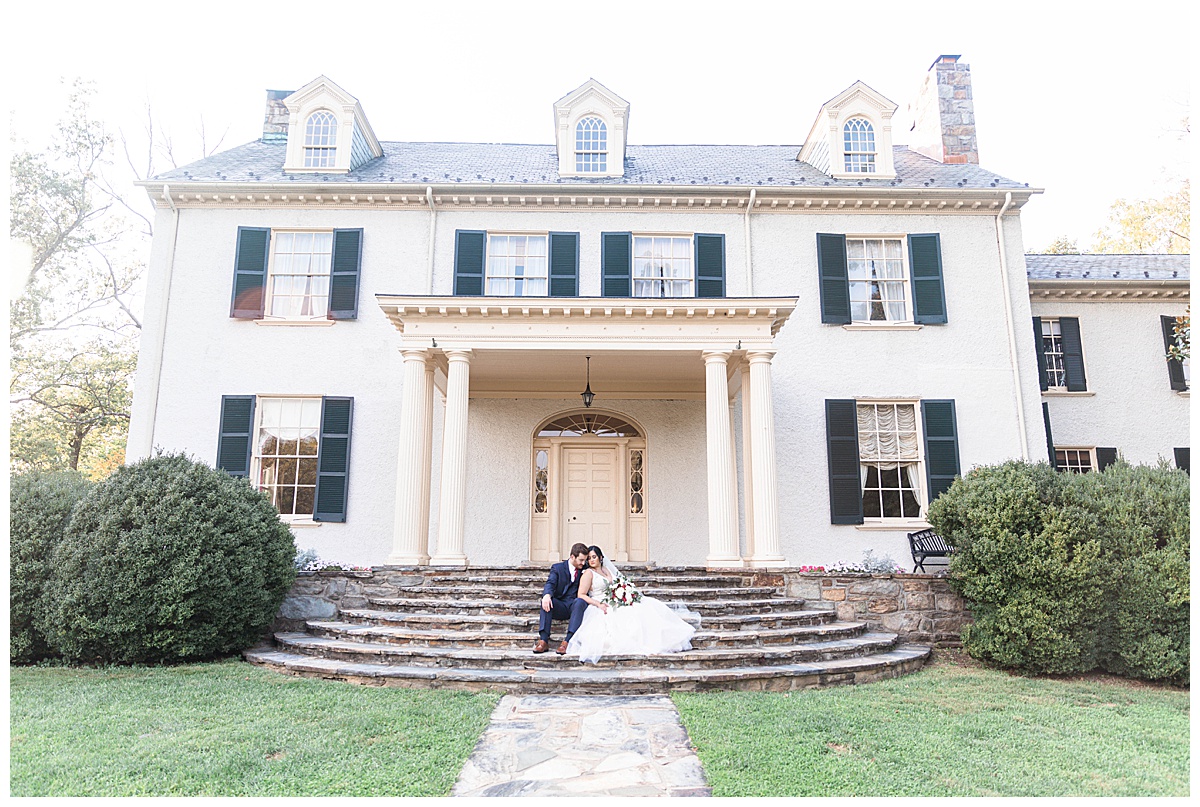 bride and groom sitting on steps at rust manor house
